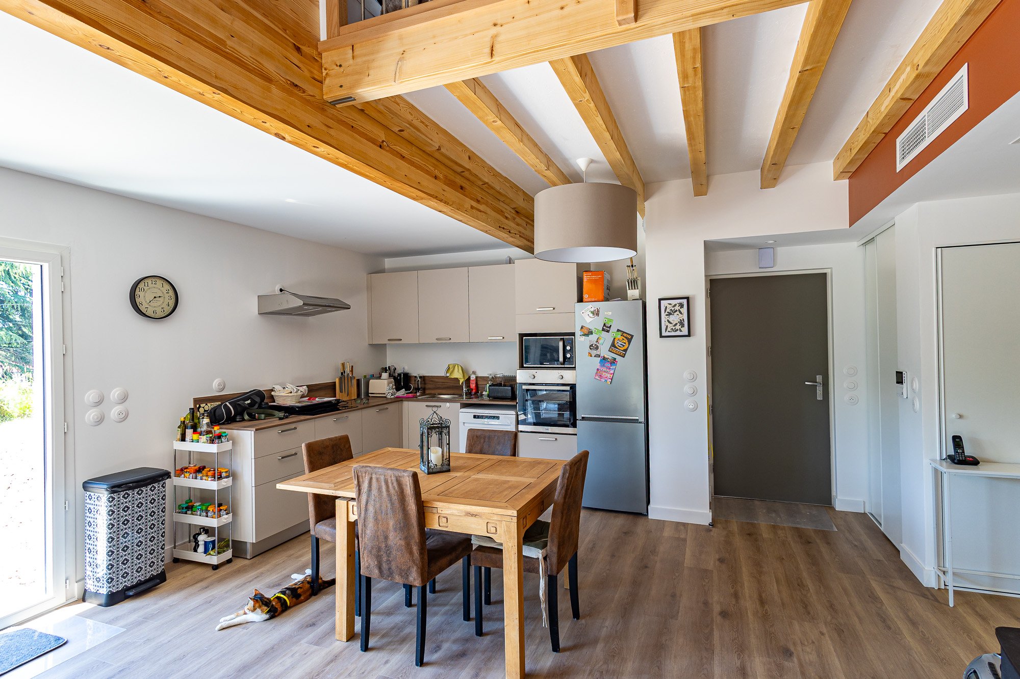 Cuisine ouverte avec table à manger et poutres bois